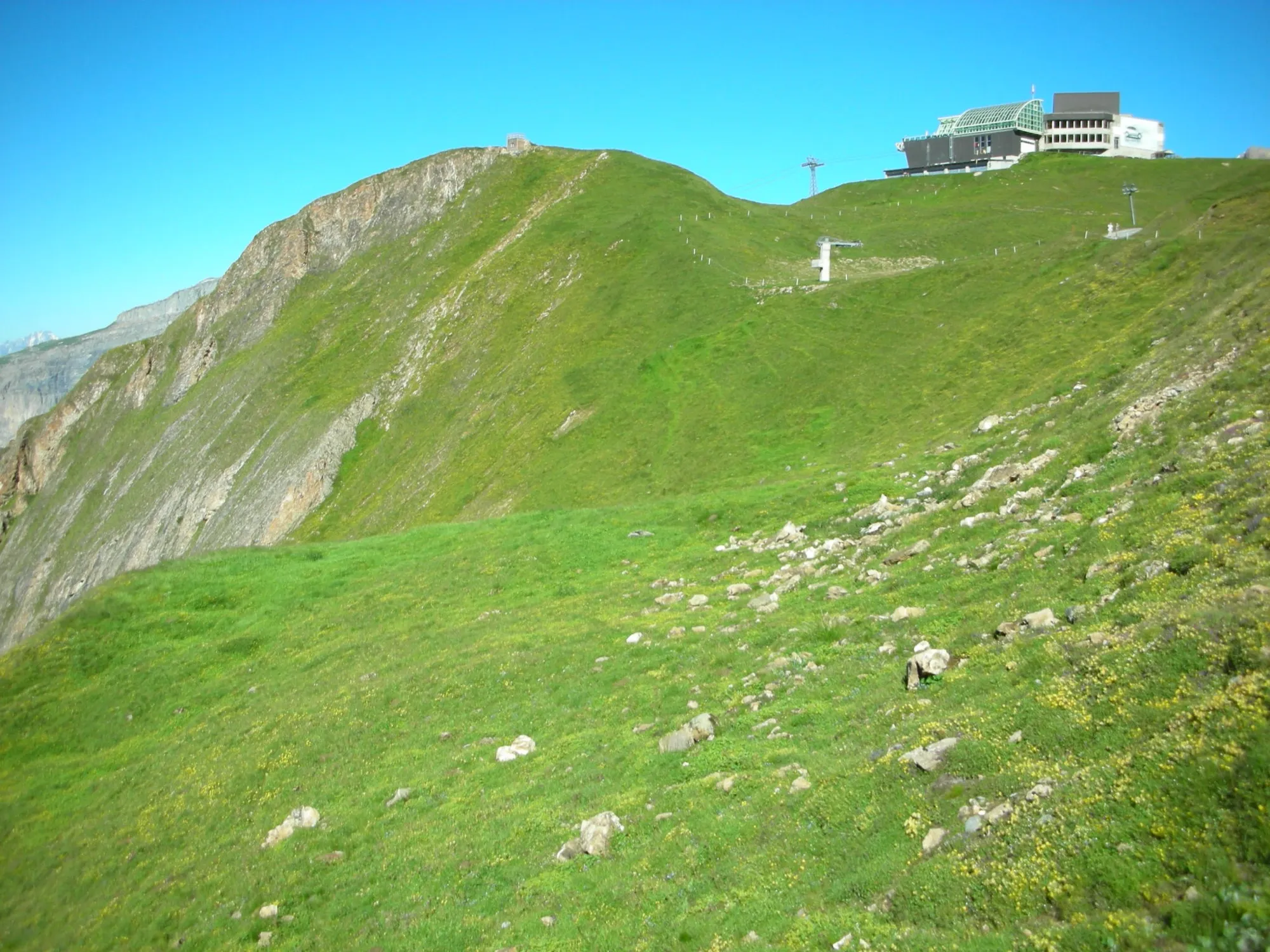 Grüner Grat auf Torrent mit der Bergstation Rinderhütte unter blauem Himmel
