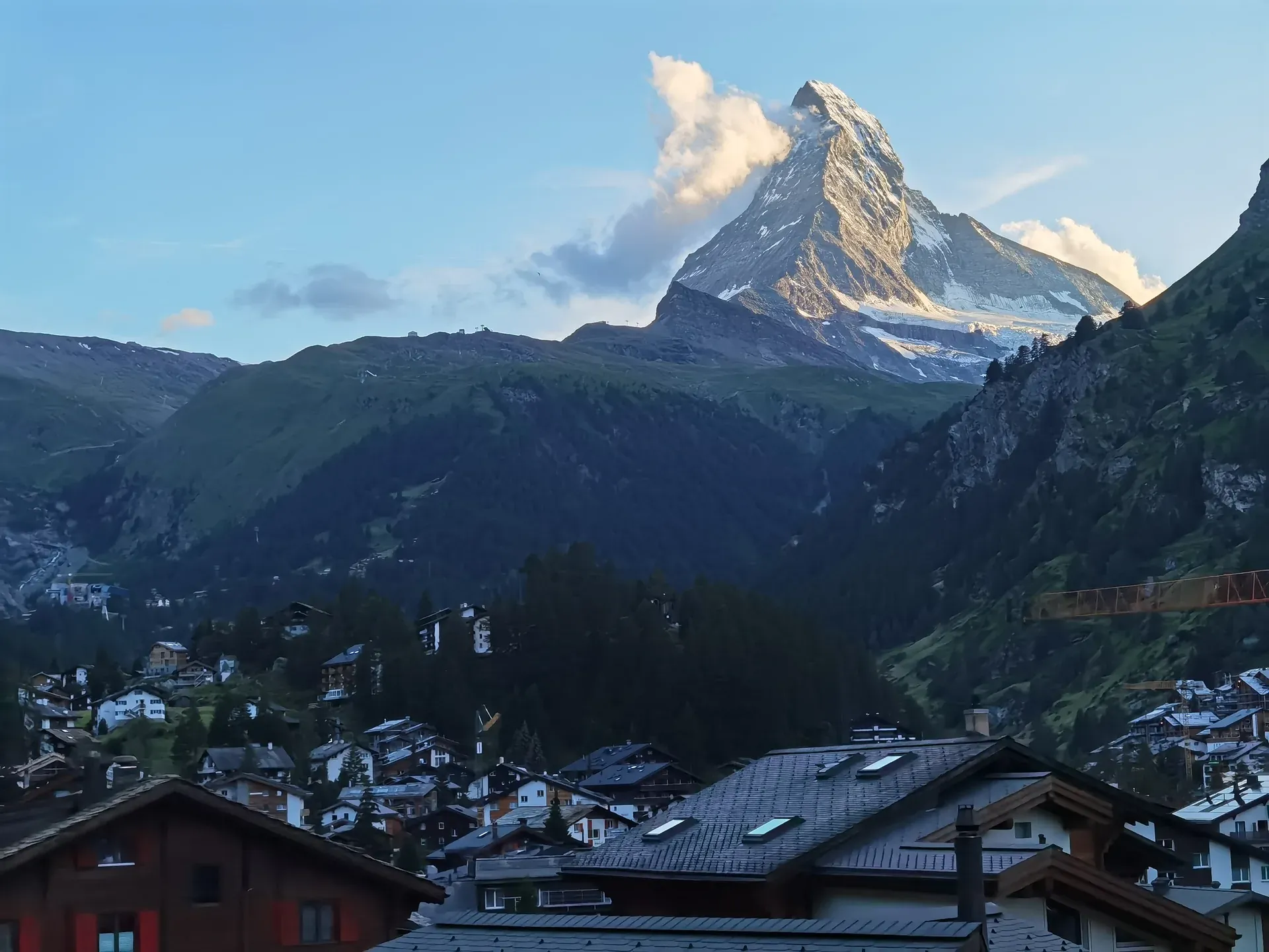 Matterhorn im Abendlicht über den Dächern eines Bergdorfs