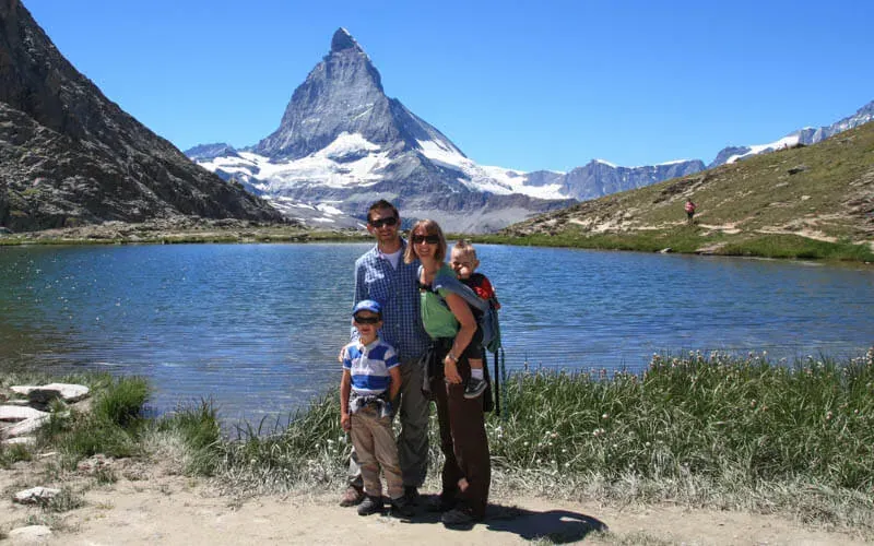 Familie mit zwei Kindern an einem Bergsee, dahinter das Matterhorn