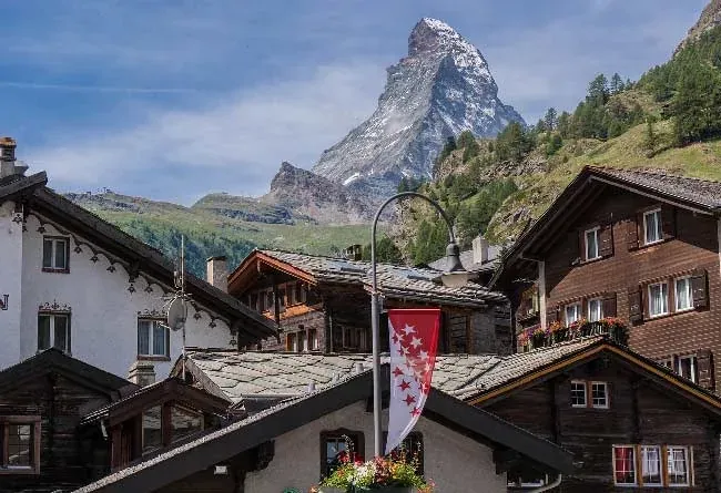 Holzhäuser und eine Valais-Fahne, dahinter das Matterhorn
