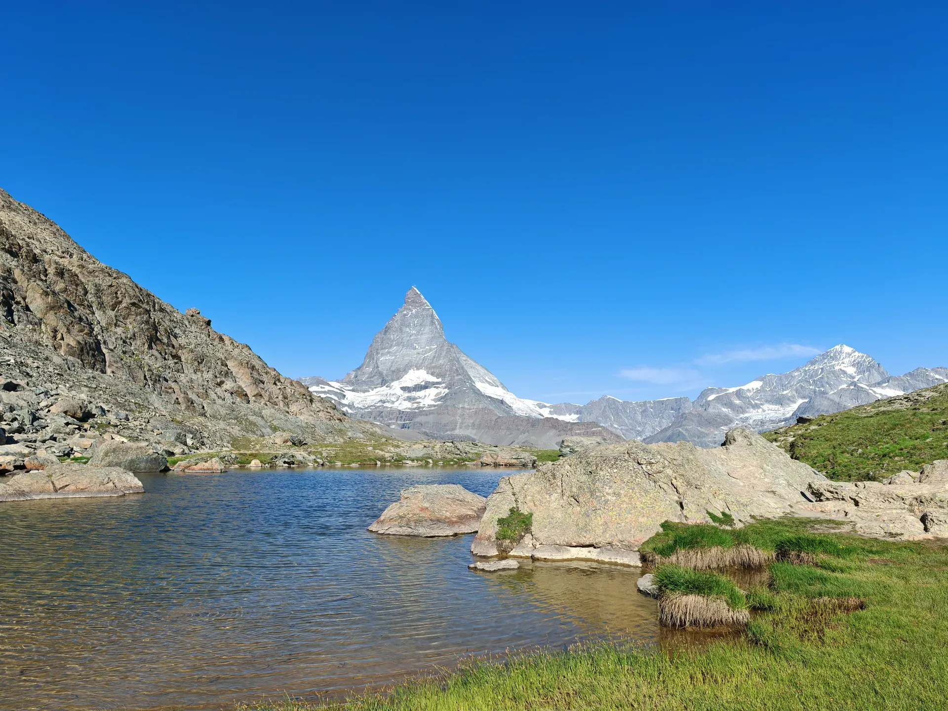 Bergsee zwischen Felsen, in der Mitte das Matterhorn